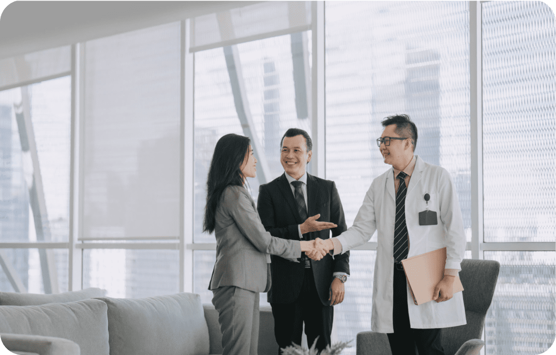 Business meeting with handshake and smiling participants.