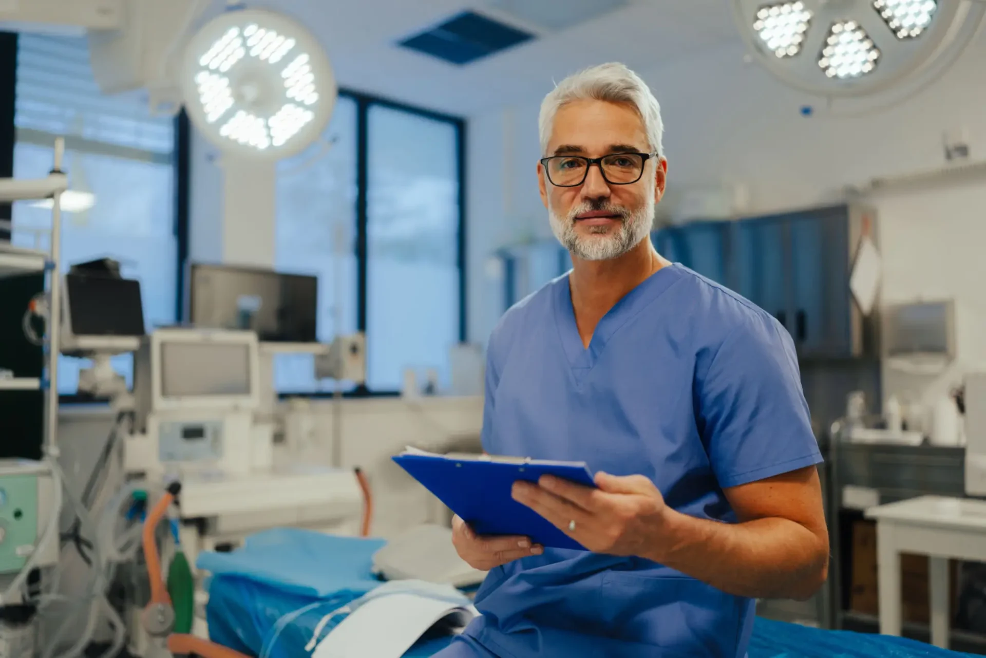 Doctor in scrubs holding a clipboard.